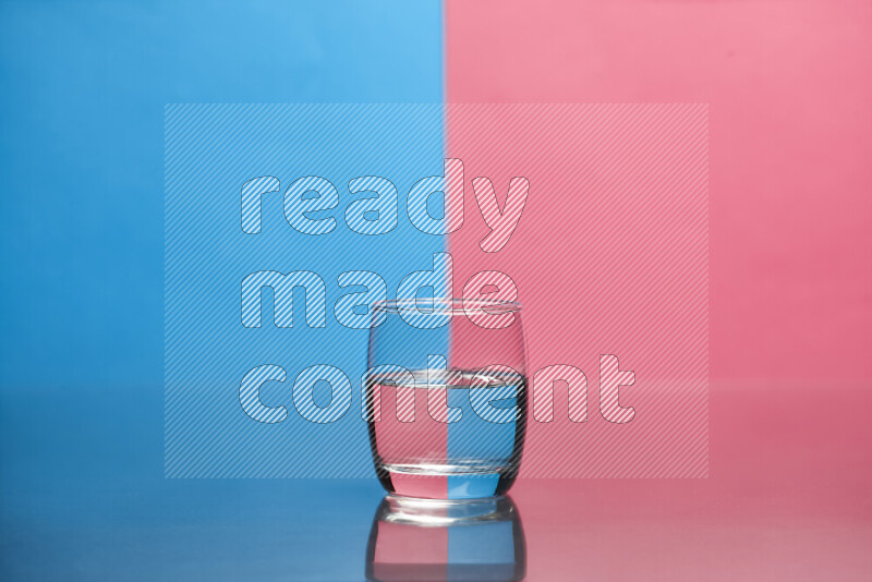 The image features a clear glassware filled with water, set against blue and pink background