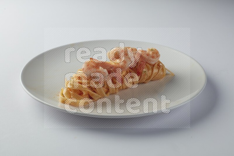 Fettuccini red sauce pasta with shrimp in a white plate on a white background