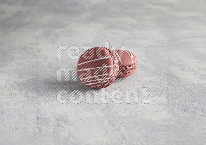 45º Shot of two Red Poppy Flower macarons on white  marble background