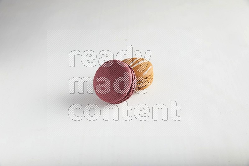 45º Shot of of two assorted Brown Irish Cream, and Red Cherry macarons on white background