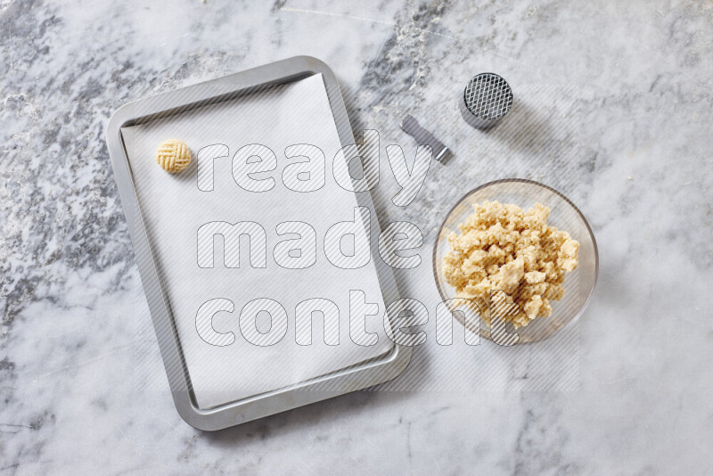 كحك خطوة بخطوة بمكوناته سمن، سكر، دقيق، سمسم، خميرة، ماء ونكهة الكحك على خلفية رخام رمادي