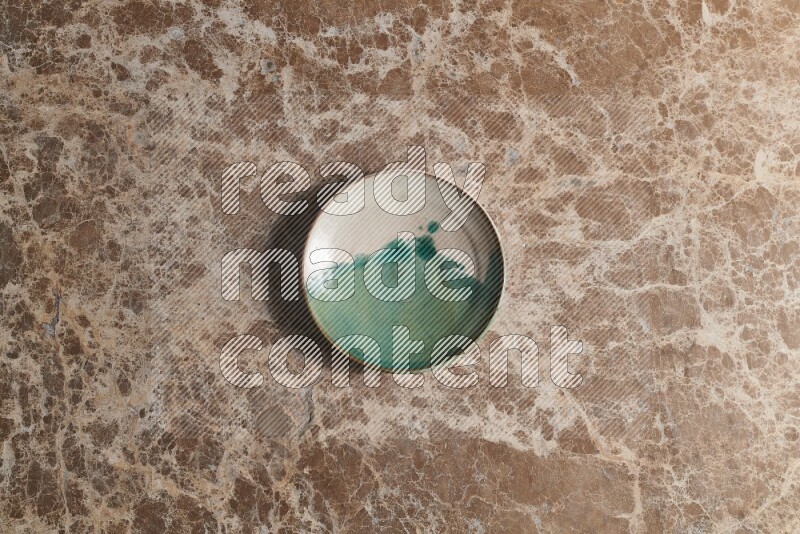 A decorative pottery plate on beige marble background