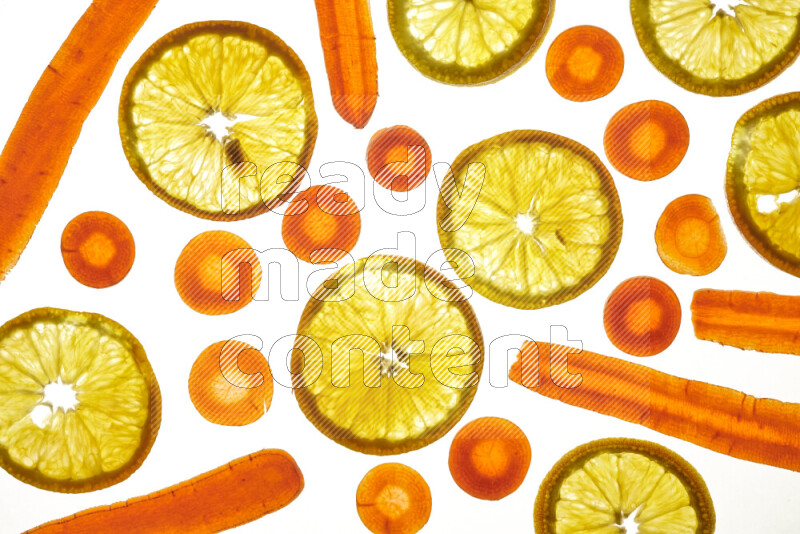 Mixed vegetables and fruits slices on illuminated white background
