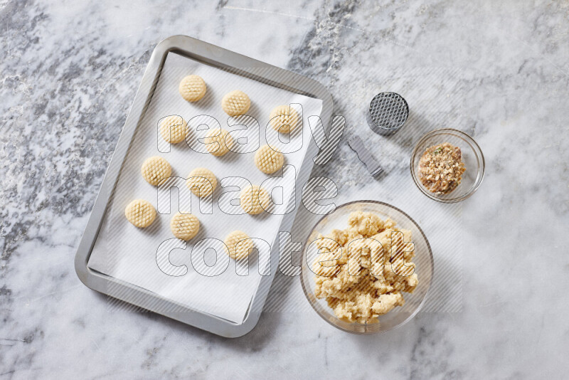 Kahk step by step with its ingredients ghee, sugar, flour, sesame, yeast, water and kahk flavor on grey marble background