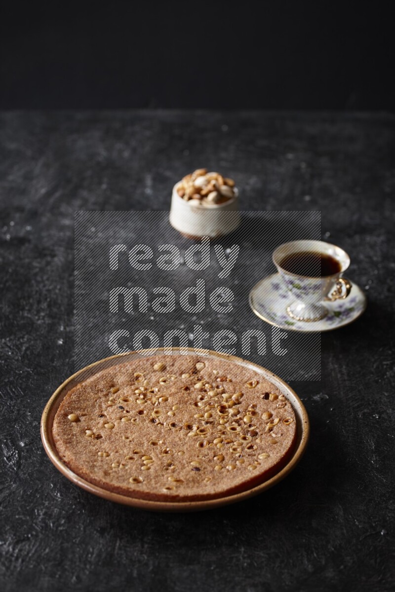 Basbousa with nuts and tea in a dark setup