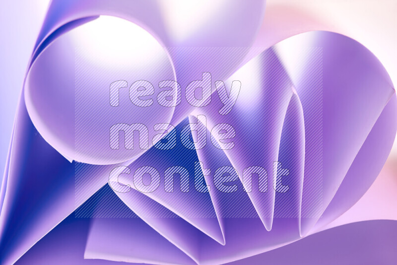 An artistic display of paper folds creating a harmonious blend of geometric shapes, highlighted by soft lighting in purple tones