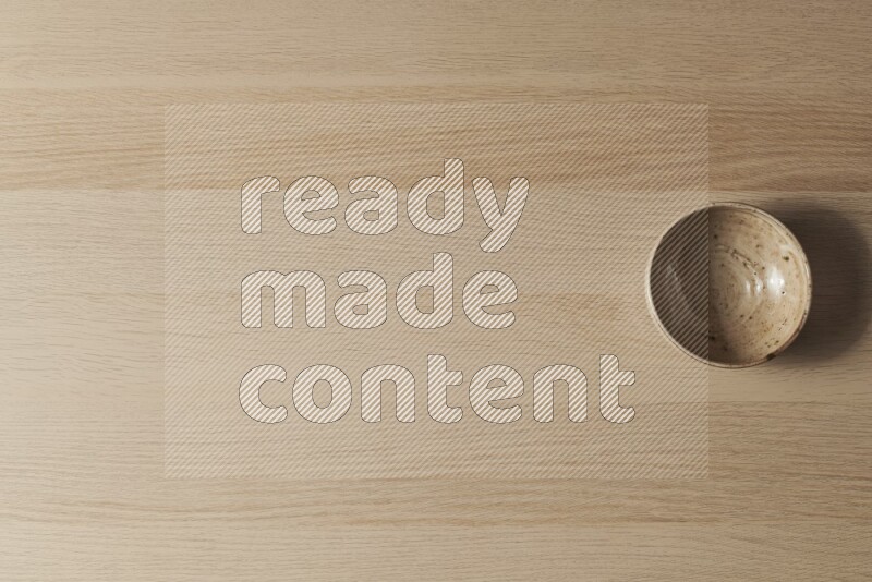 وعاء فخاري متعدد الألوان على خلفية خشبية فاتحة