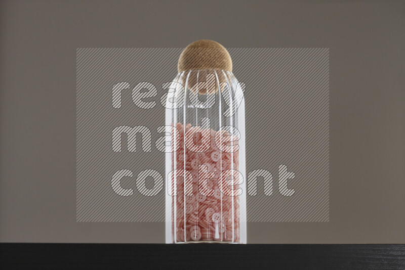 أزرار متنوعة في وعاء زجاجي علي خلفية سوداء