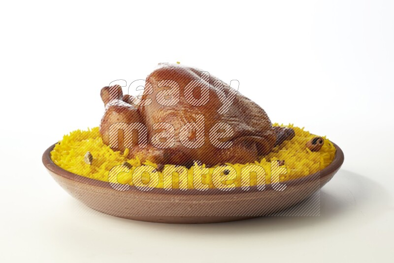 yellow basmati Rice with whole roasted chicken  on a pottery plate  direct  on white background