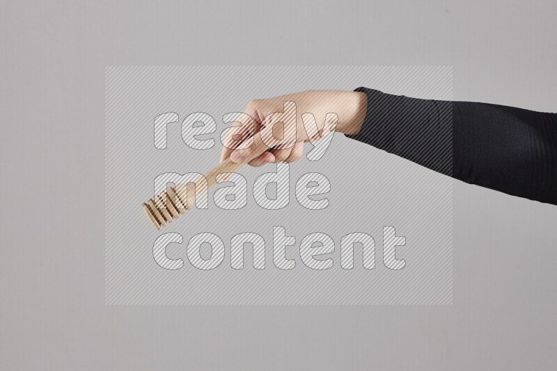 A woman in black abaya holding different wooden essentials in different positions