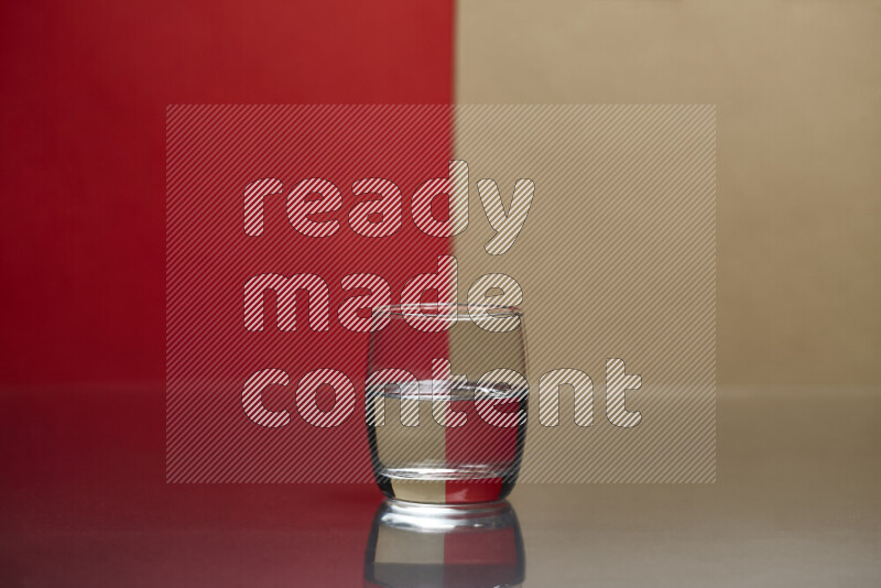 The image features a clear glassware filled with water, set against red and beige background