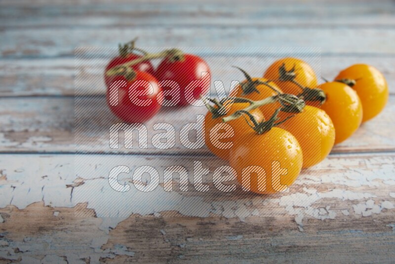 Mixed cherry tomato veins on a textured light blue wooden background 45 degree