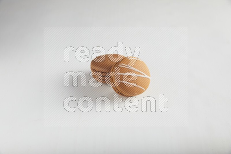 45º Shot of of two assorted Brown Irish Cream, and Brown Coffee macarons  on white background