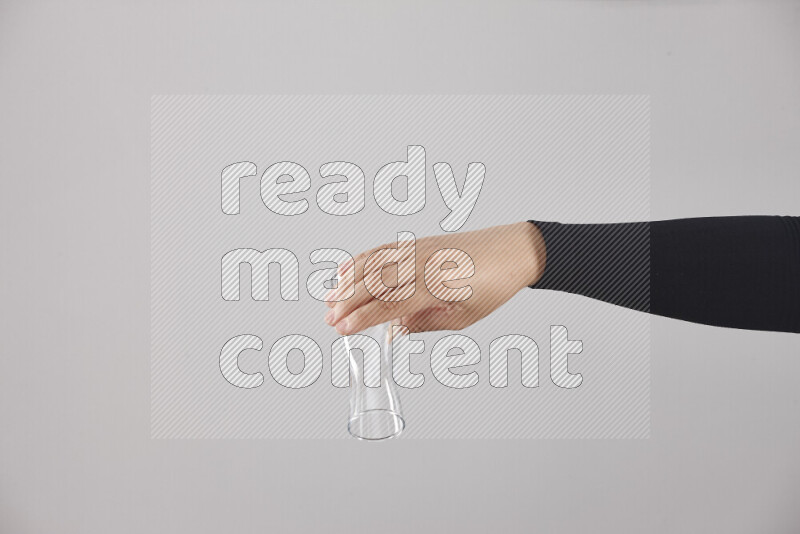 A woman in black abaya holding different glassware in different positions