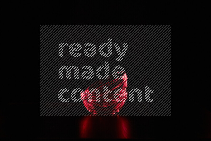 Glassware with rim light in red against black background