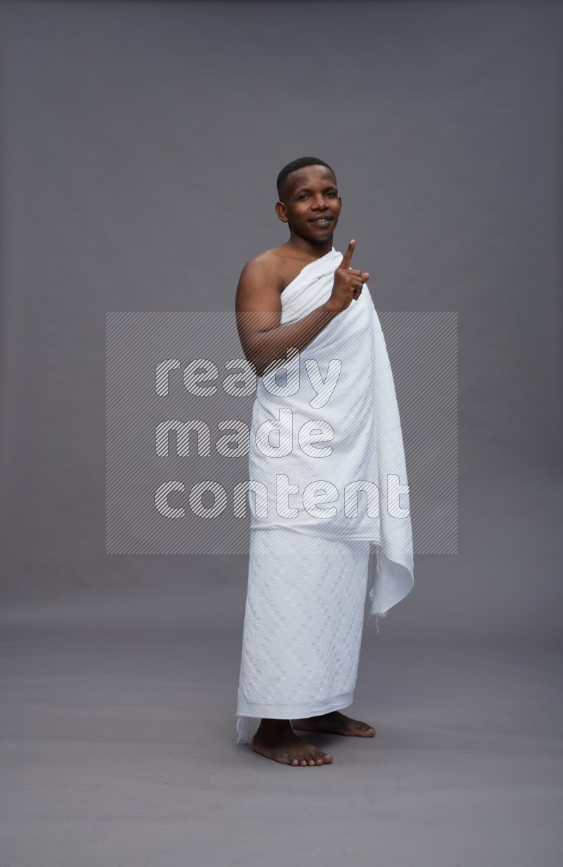 A man wearing Ehram Standing Interacting with the camera on gray background