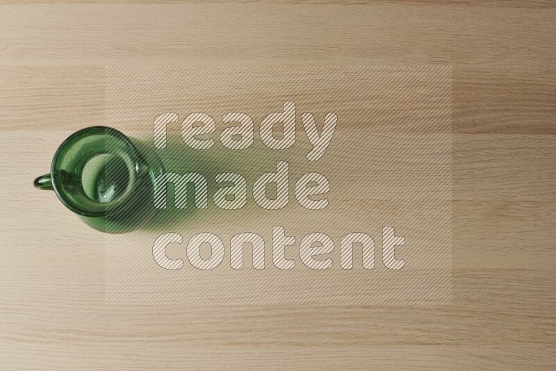 إبريق زجاجي فارغ على خلفية خشبية فاتحة