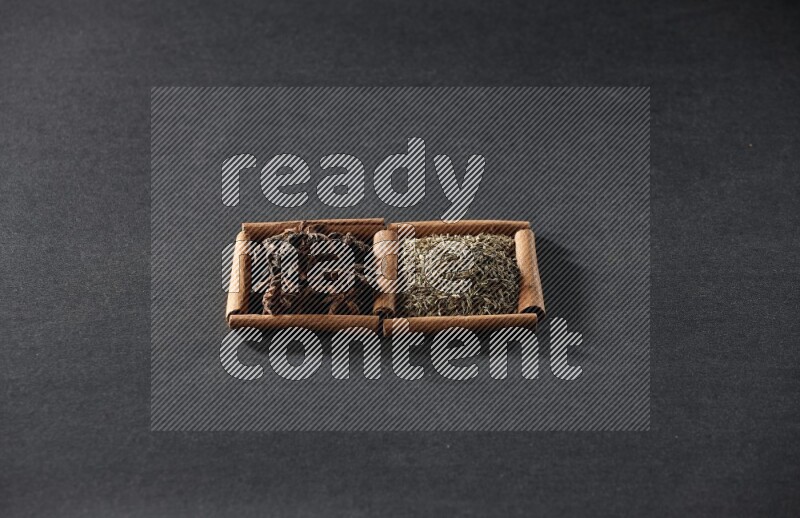 2 squares of cinnamon sticks full of cumin and star anise on black flooring