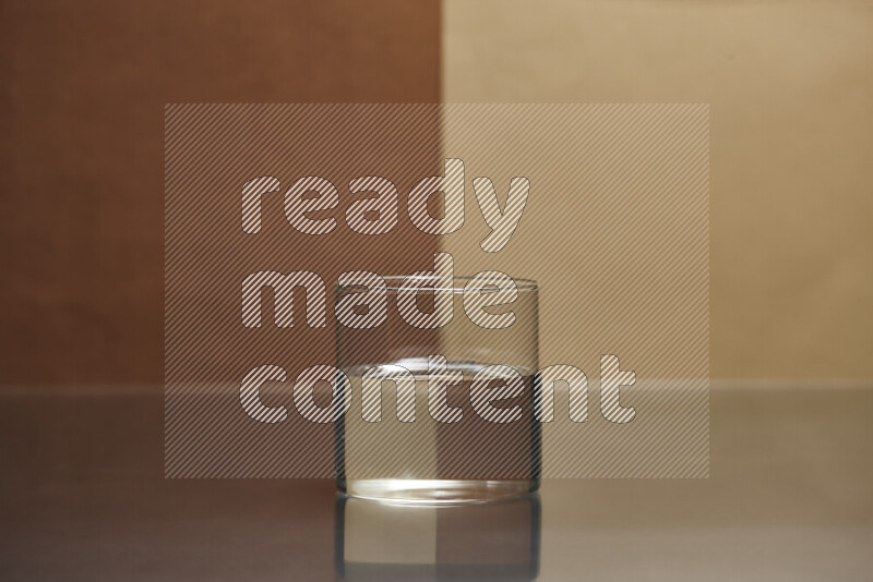 The image features a clear glassware filled with water, set against brown and beige background