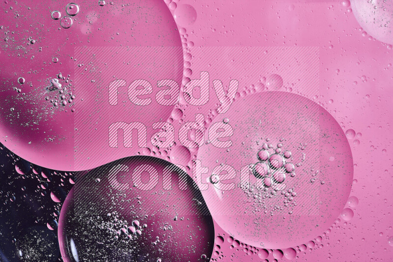 لقطات مقربة لفقاعات من الزيت على سطح الماء باللون الأسود والوردي