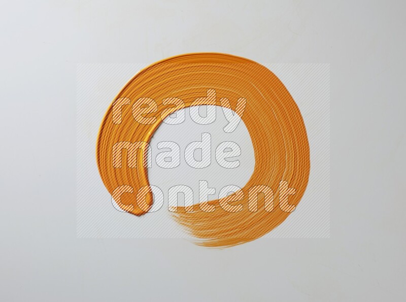 An orange circular painting brush stroke on white background
