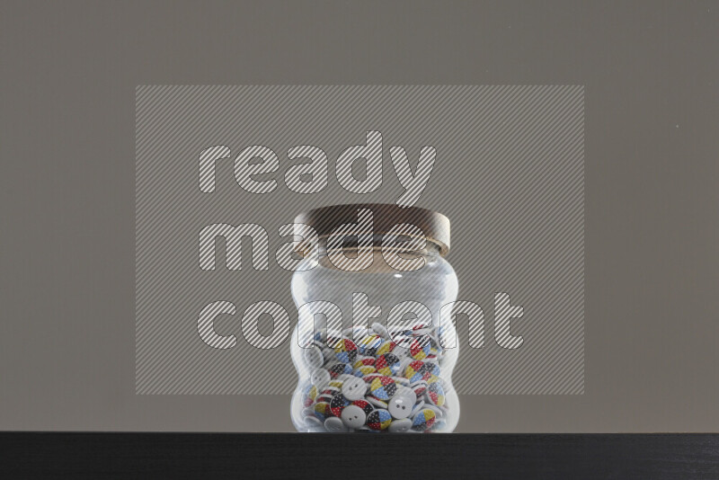Buttons in a glass jar on black background