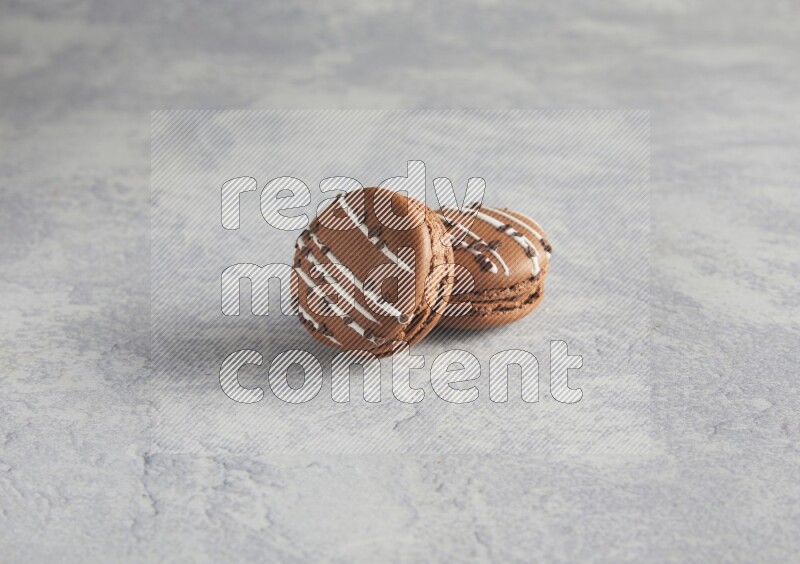 45º Shot of two Brown white marbleChocolate Caramel macarons  on white  marble background