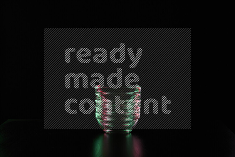 Glassware with rim light in red and green against black background