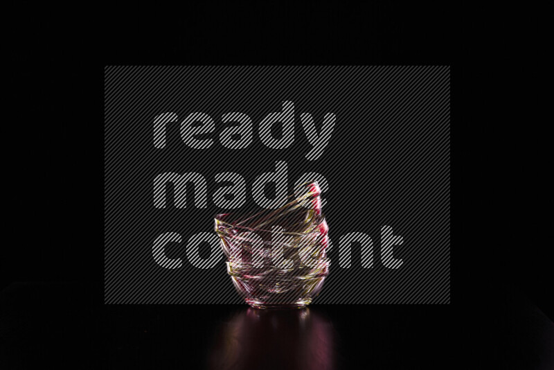 Glassware with rim light in red and yellow against black background