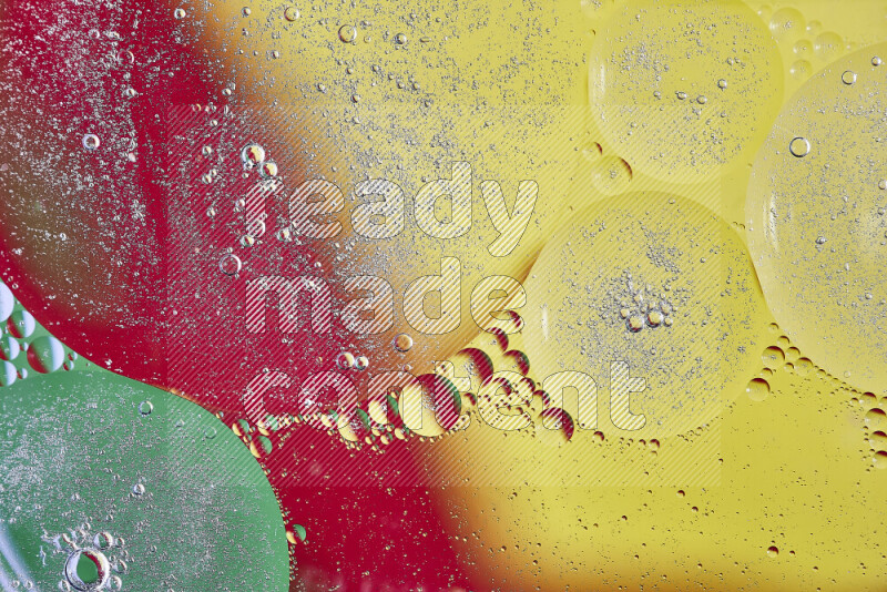Close-ups of abstract oil bubbles on water surface in shades of yellow, green and red