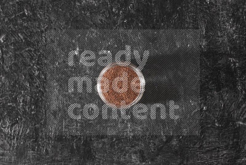 وعاء زجاجي ممتلئ ببذور حب الرشاد على أرضية سوداء