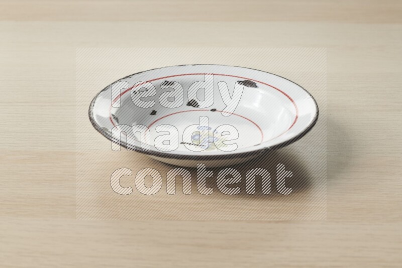 صحن معدني عتيق على خلفية خشبية فاتحة