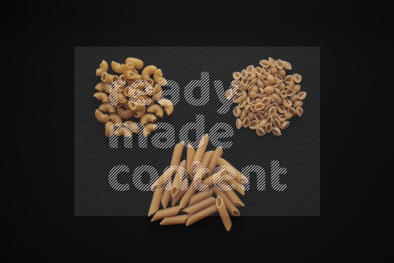 Different pasta types in bunches on black background