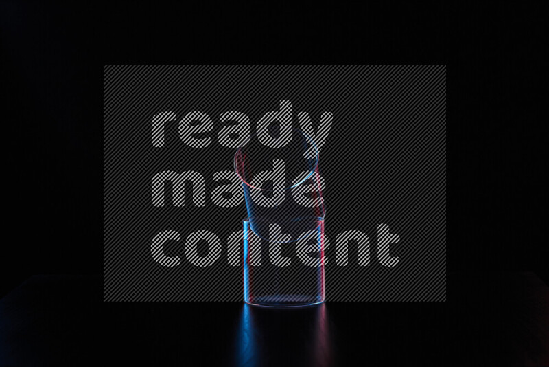 Glassware with rim light in red and blue against black background