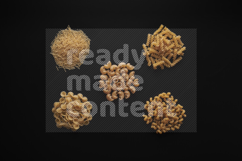 Different pasta types in bunches on black background