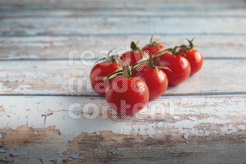 Red cherry tomato vein on a textured blue wooden background 45 degree