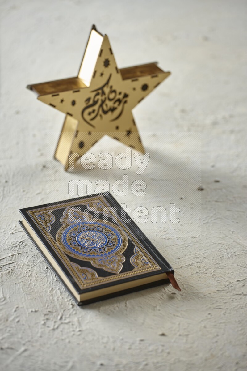 A wooden golden star lantern with different drinks, dates, nuts, prayer beads and quran on textured white background