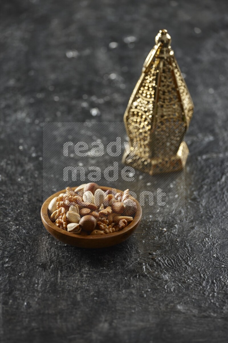 A golden lantern with different drinks, dates, nuts, prayer beads and quran on textured black background