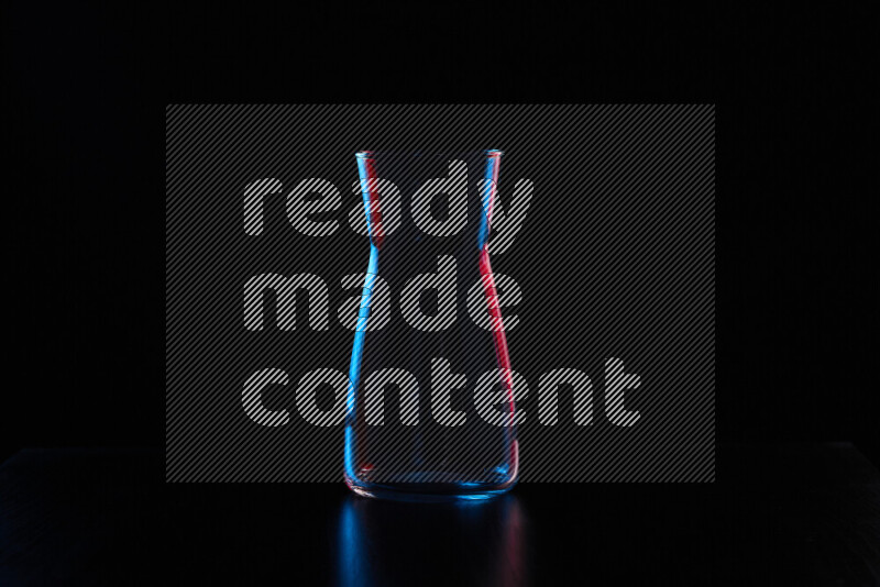 Glassware with rim light in red and blue against black background