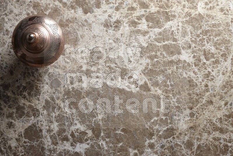 A lantern placed on a beige marble background