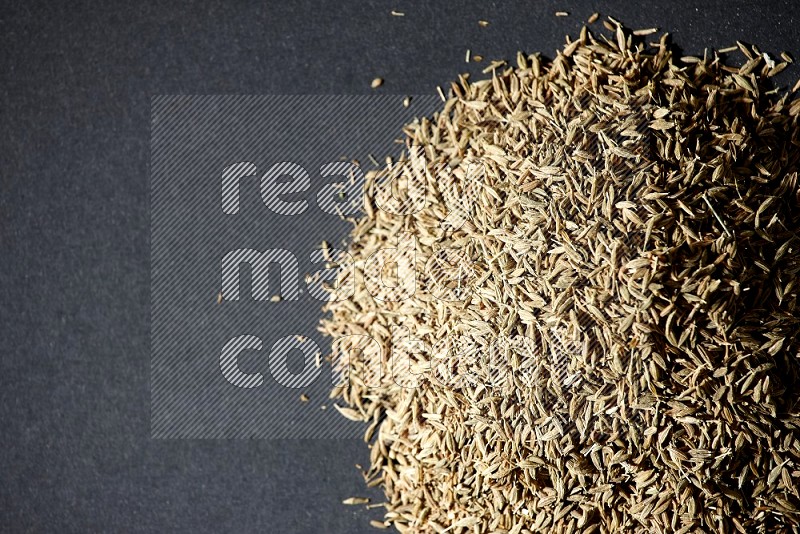 Cumin seeds on black flooring