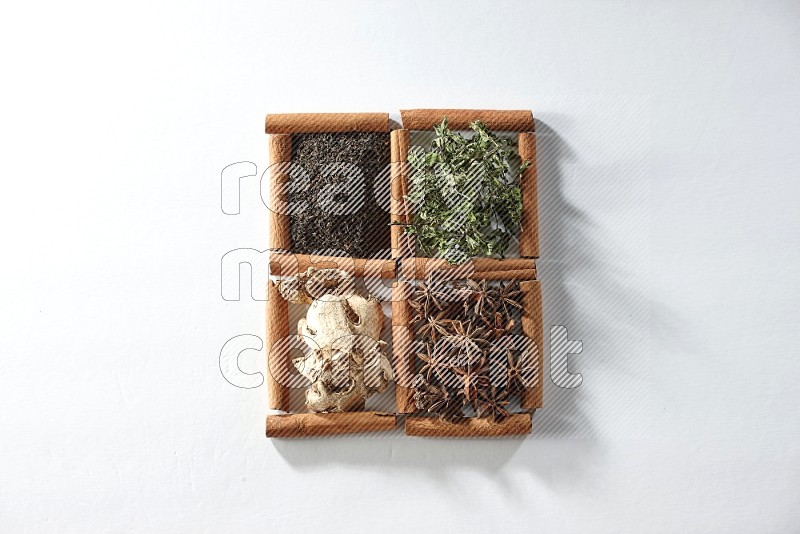 4 squares of cinnamon sticks full of tea, mint, star anise and ginger on white flooring