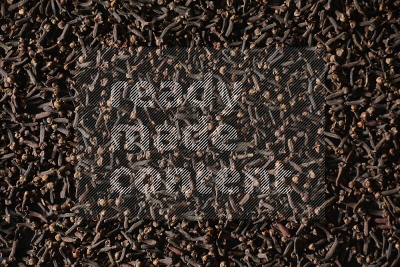 Cloves spread on black flooring