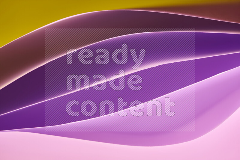 This image showcases an abstract paper art composition with paper curves in purple and gold gradients created by colored light