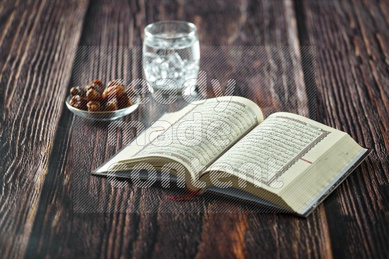 Quran with dates, prayer beads and different drinks all placed on wooden background