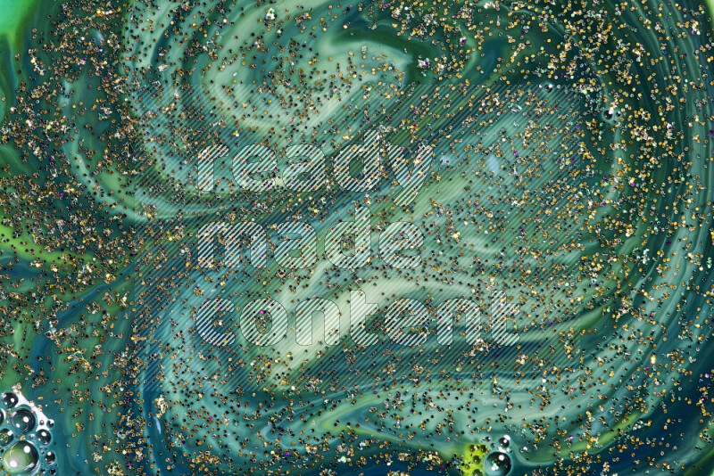 A close-up of sparkling gold glitter scattered on swirling blue and green background