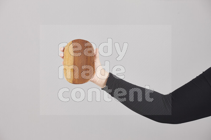 A woman in black abaya holding different wooden essentials in different positions