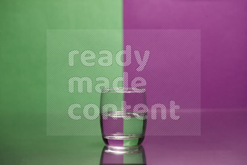 The image features a clear glassware filled with water, set against green and purple background