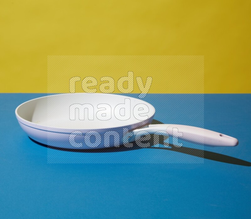 white pan on yellow and Blue background