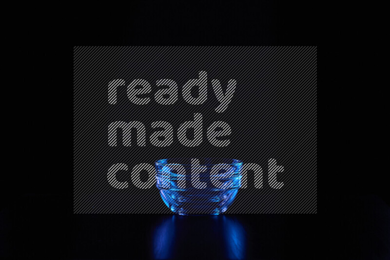 Glassware with rim light in blue against black background